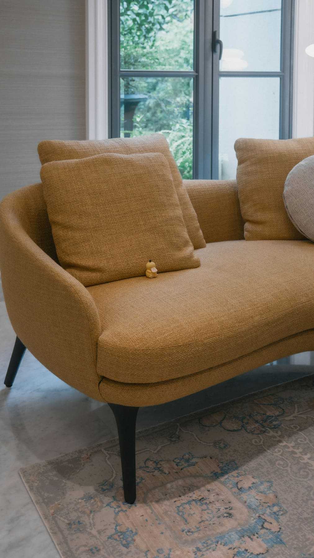 A curved armchair in warm mustard fabric