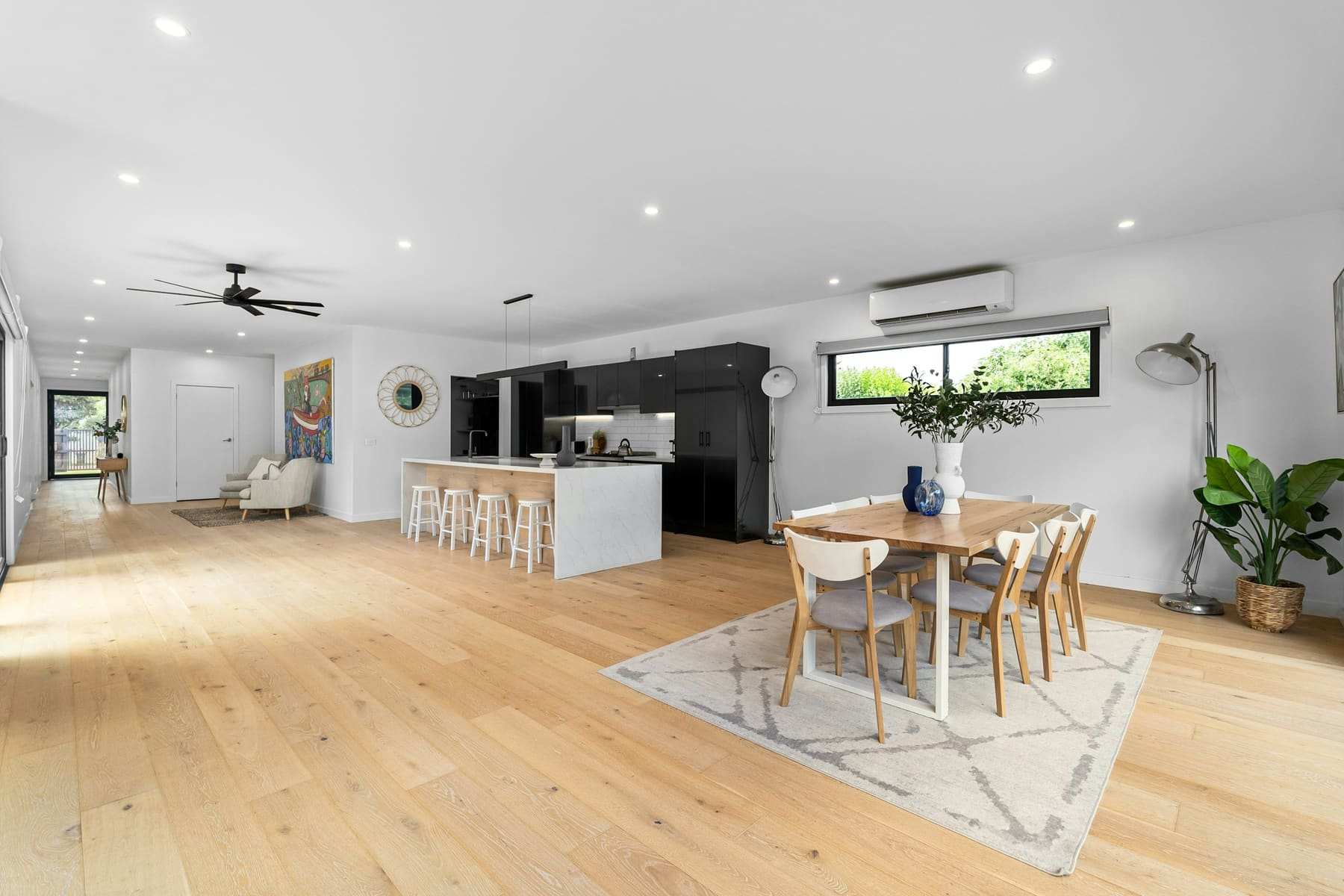 An open-plan living and dining room with pale wood floors